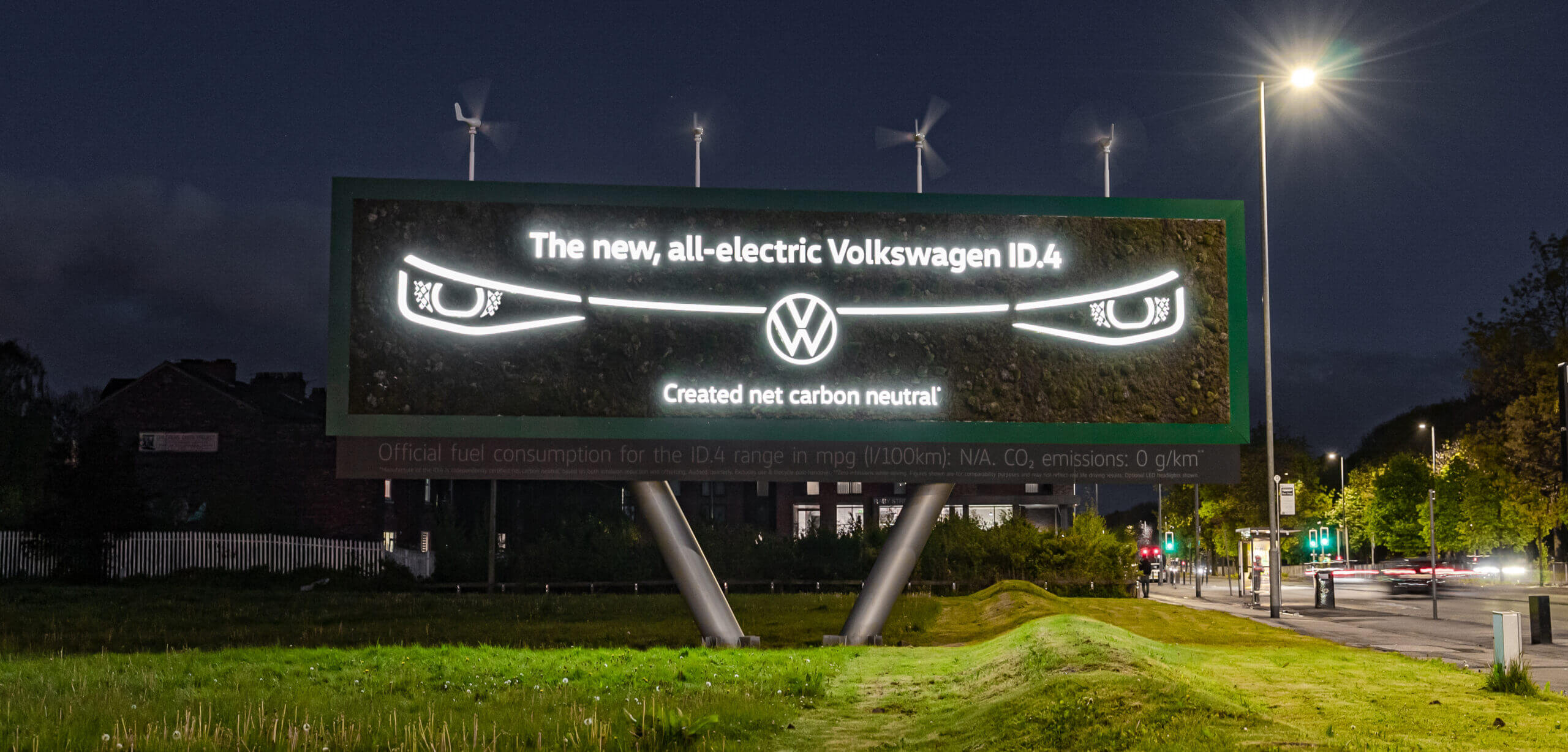 The Volkswagen ID.4 Living Billboard, lit up in the darkness.