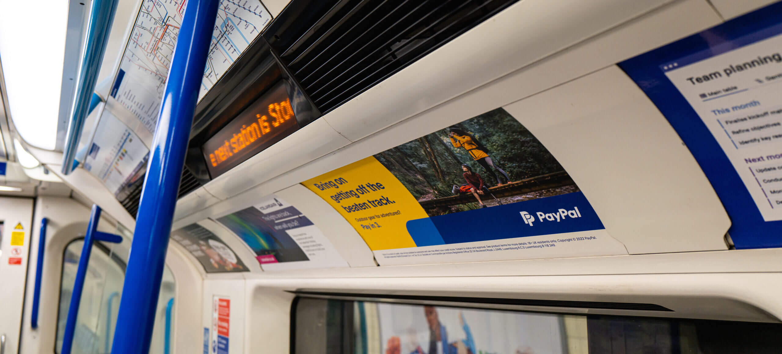 PayPal's pay in 3 campaign on a train card inside of a London Underground tube train.