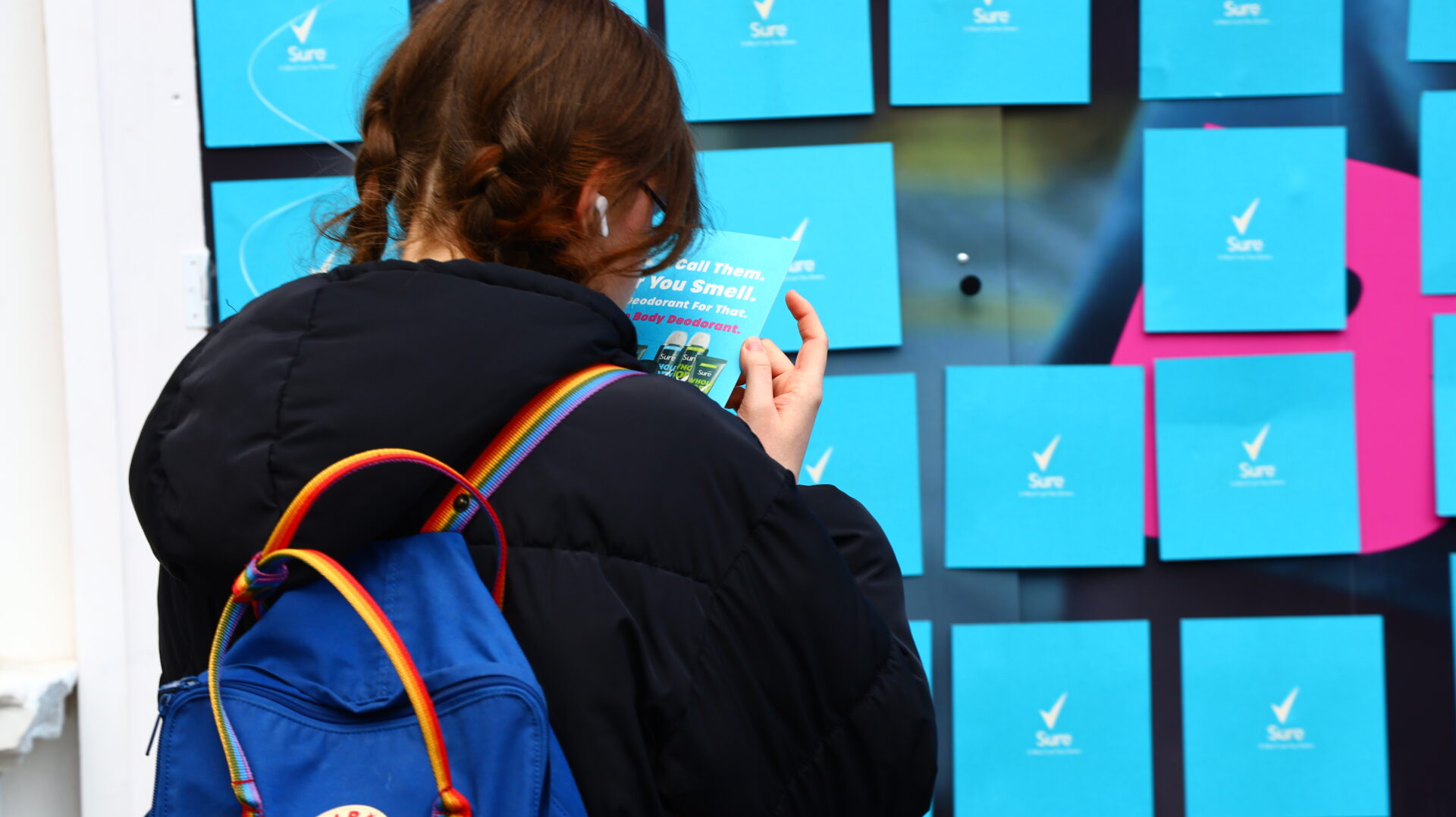 Gen Z girl engaging with an Out of Home (OOH) ad display.